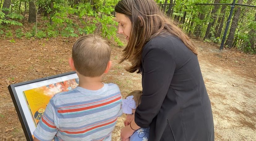 Faith Phillips and her niece and nephew explore the story walk at Lake Rim Park. (Spectrum News 1/Natalie Mooney)